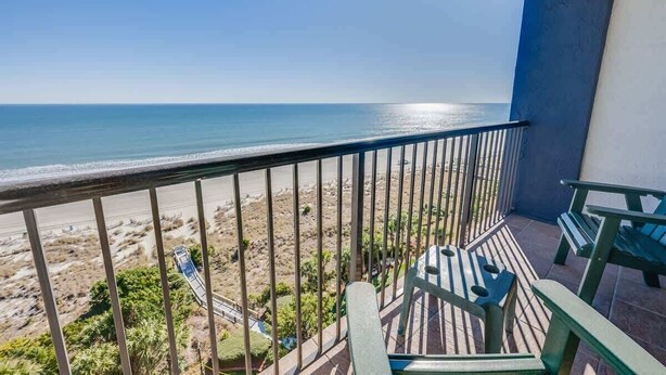 Un balcón con vista a la playa y el océano.