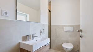 A modern bathroom with a white sink, mirror, and toilet. - Accommodation " Ana-Marija " (Vodice)