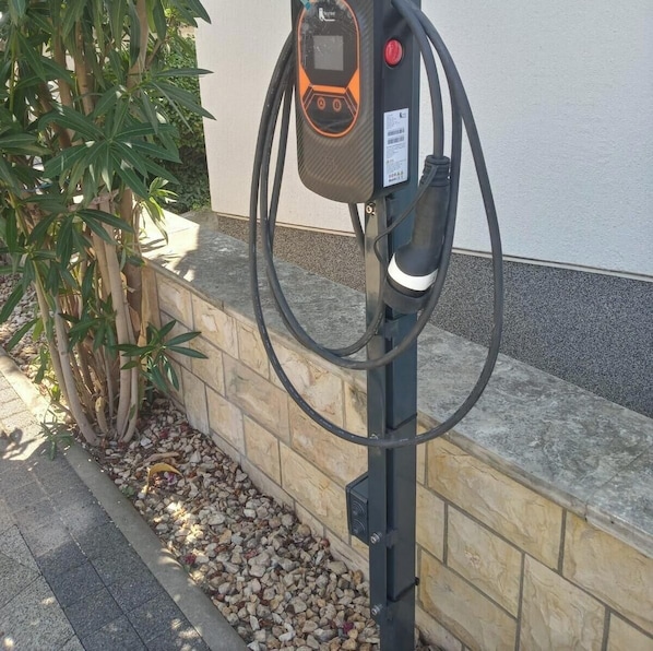 An electric vehicle charging station with a digital display, a cable, and a wall-mounted box. - Accommodation " Ana-Marija " (Vodice)