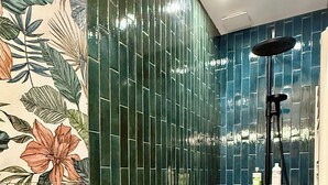 A bathroom with a shower, tiled walls, and a floral wallpaper design. - Id-home Le Saint Nicolas (Nantes)