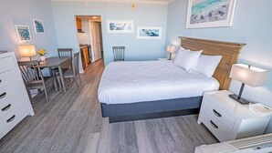 Une chambre à coucher avec un lit, des tables de chevet, un bureau et des chaises.