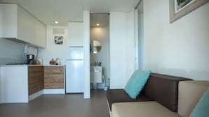 A compact living space with a kitchenette, a sofa, and a dining area.