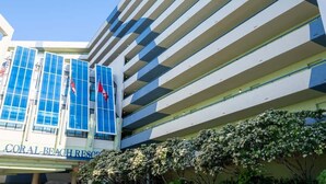 A multi-story hotel with a modern design, featuring balconies and large windows. - Direct Oceanfront at Coral Beach,Nice,Heated Pools (Myrtle Beach)