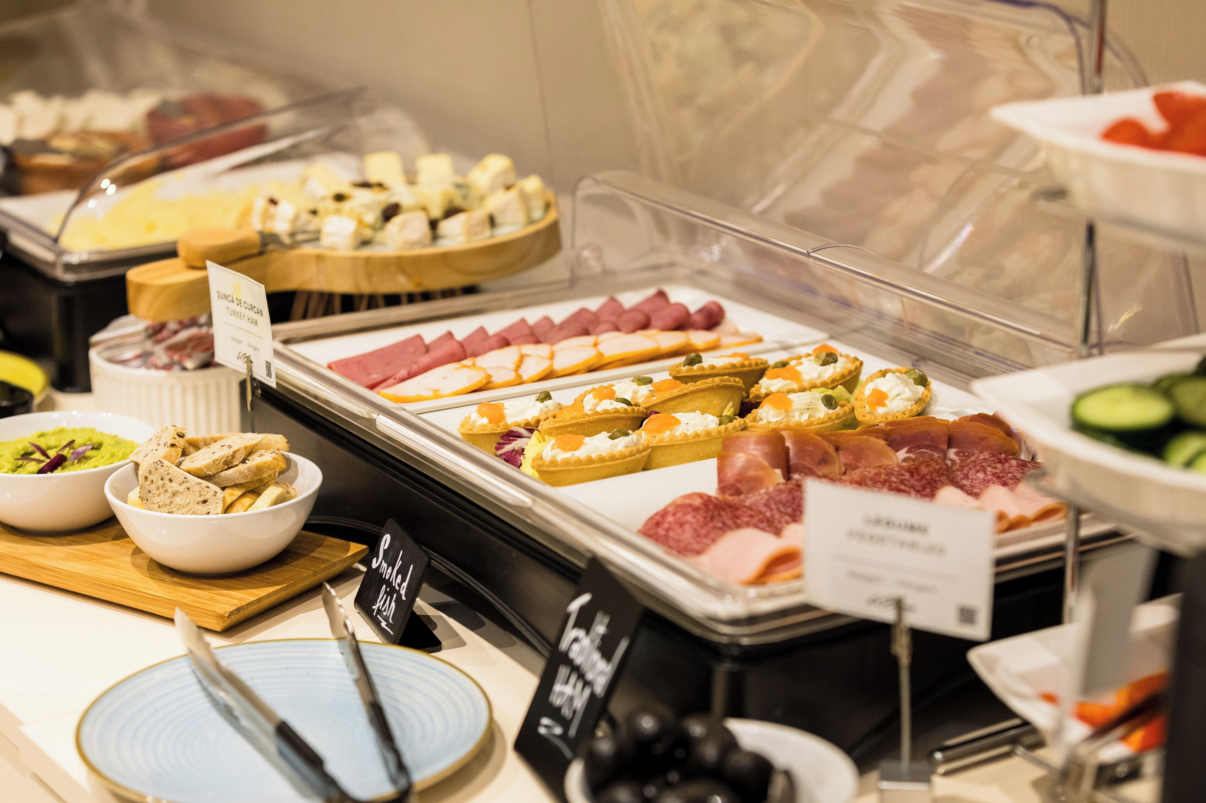 Ein Buffet mit verschiedenen Speisen, darunter Fleisch, Käse und Gebäck.