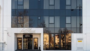 A modern hotel with a glass facade, a sign reading "Le Blanc Hotel," and a visible entrance with steps leading up to it. - Le Blanc Cotroceni hotel (Bucharest)