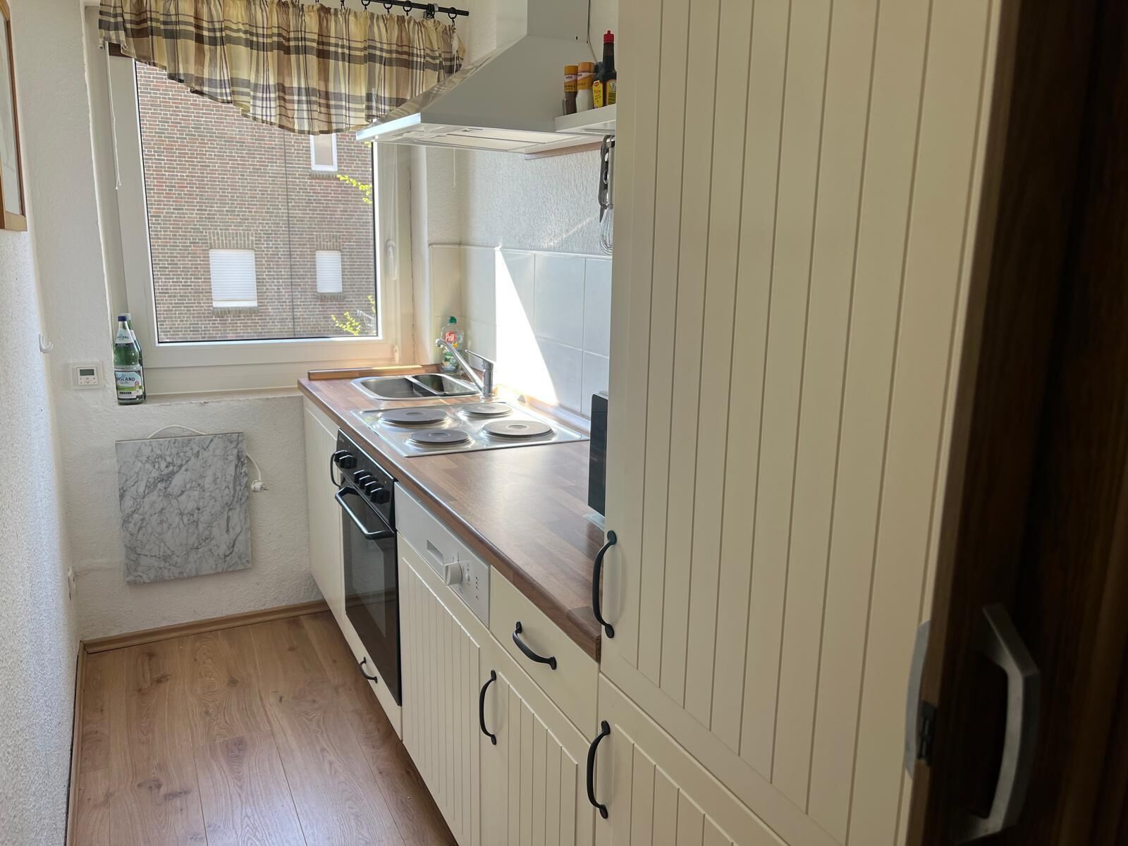 Una cocina funcional con ventana, un lavamanos y una estufa.