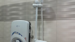 A bathroom with a wall-mounted shower unit, including a handheld showerhead and a control panel. - Stan Lodge Babati (Babati)
