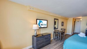 A hotel room with a bed, a desk, a chair, a TV, and a dresser. - New Landmark Resort Direct Oceanfront - Low Floor! (Myrtle Beach)