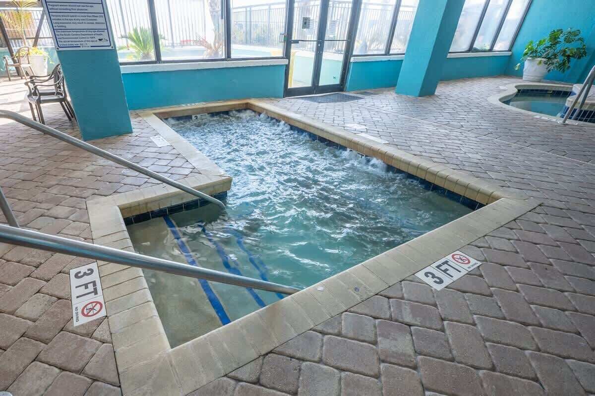 Un espace intérieur avec un jacuzzi, doté d’un sol carrelé et d’une piscine dont la profondeur maximale est indiquée à 3 pieds.