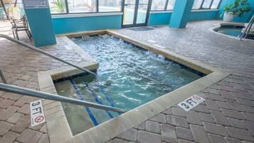 Un espace intérieur avec un jacuzzi, doté d’un sol carrelé et d’une piscine dont la profondeur maximale est indiquée à 3 pieds.