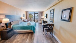 A hotel room with a bed, bedside tables, a desk, and a chair. - New Landmark Resort Direct Oceanfront - Low Floor! (Myrtle Beach)