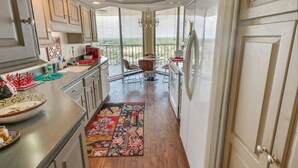 A kitchen with a dining area, large windows, and a view of the outdoors. - Newly Added Maisons, Large Balconies - City View! (Myrtle Beach)