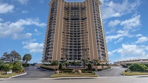 A tall, multi-story hotel with a central entrance and a landscaped area in front. - Newly Added - City Views - Private Maisons Sur Mer (Myrtle Beach)