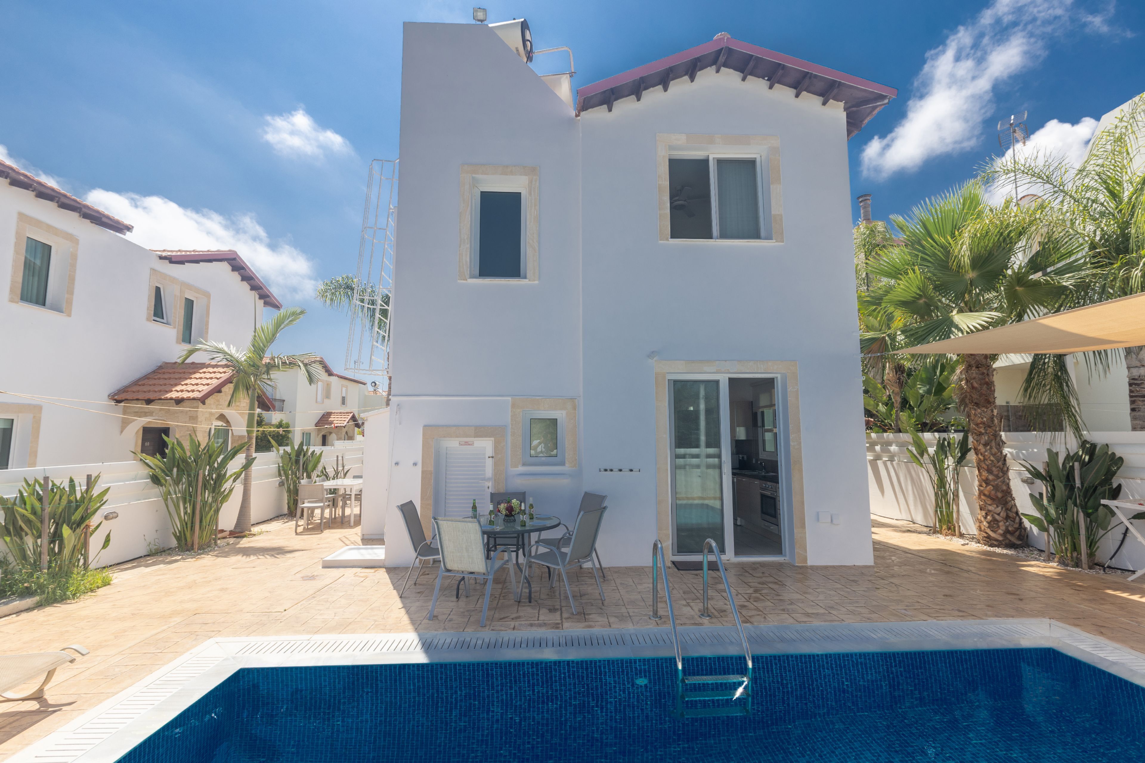 Un bâtiment à deux étages avec une piscine en premier plan.