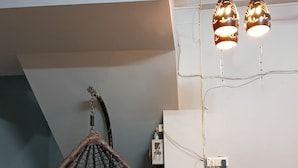 Una stanza con una poltrona sospesa, un bancone della cucina e luci a sospensione.