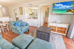 Relax in a cozy seating area with a sofa, ottoman, and flat-screen TV.
