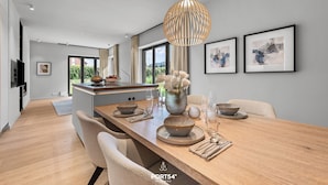 Une cuisine moderne dotée d’un îlot central, de luminaires suspendus et d’œuvres d’art encadrées accrochées aux murs.
