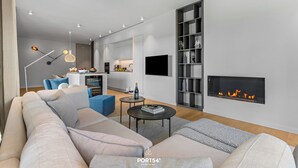 Un salon moderne avec un canapé, une table basse et une cheminée.