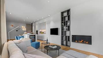 A modern living room with a sofa, coffee table, and fireplace.