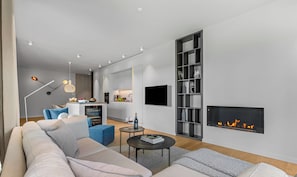 Una sala de estar moderna con sofá, mesa de centro y chimenea.