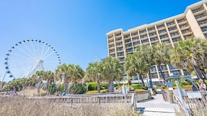 A beachfront hotel with a Ferris wheel, palm trees, and a boardwalk. - Direct Ocean Front, The Pavilion, Pools, Boardwalk (Myrtle Beach)