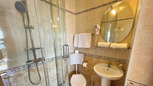 A bathroom with a glass-enclosed shower, a toilet, a sink, and a mirror. - Soba Kira 6 (Dramalj)