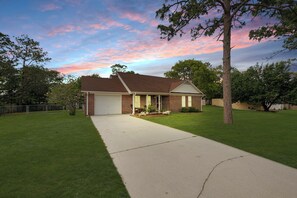 A single-story brick house with a front garage, a well-maintained lawn, and a tree in the foreground. - Private Saltwater Pool, No Stairs, Sleeps 8, Bunk Bed, Games, Gym, Near Beaches! (Wilmington)