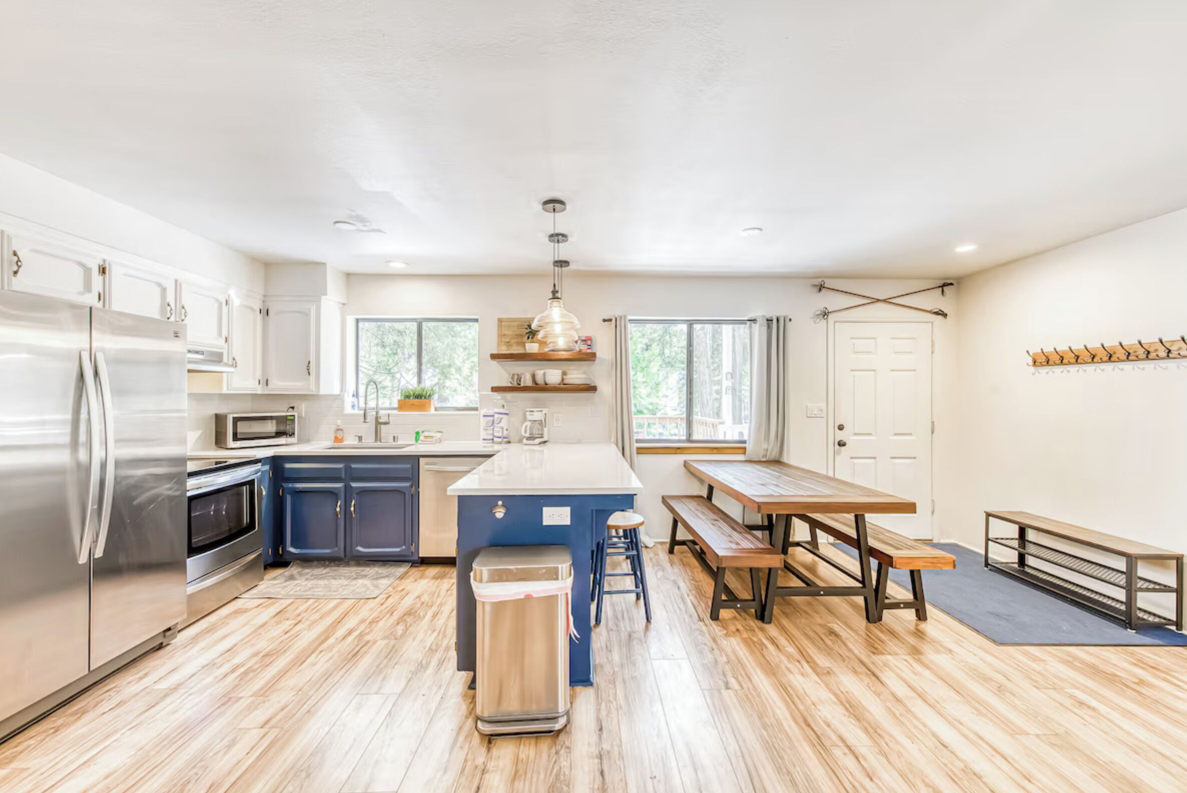 Una cocina moderna con una isla central, electrodomésticos de acero inoxidable y un banco de madera.