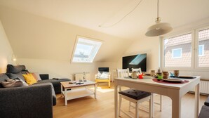 Un salon moderne avec un canapé, une table à manger et un téléviseur.