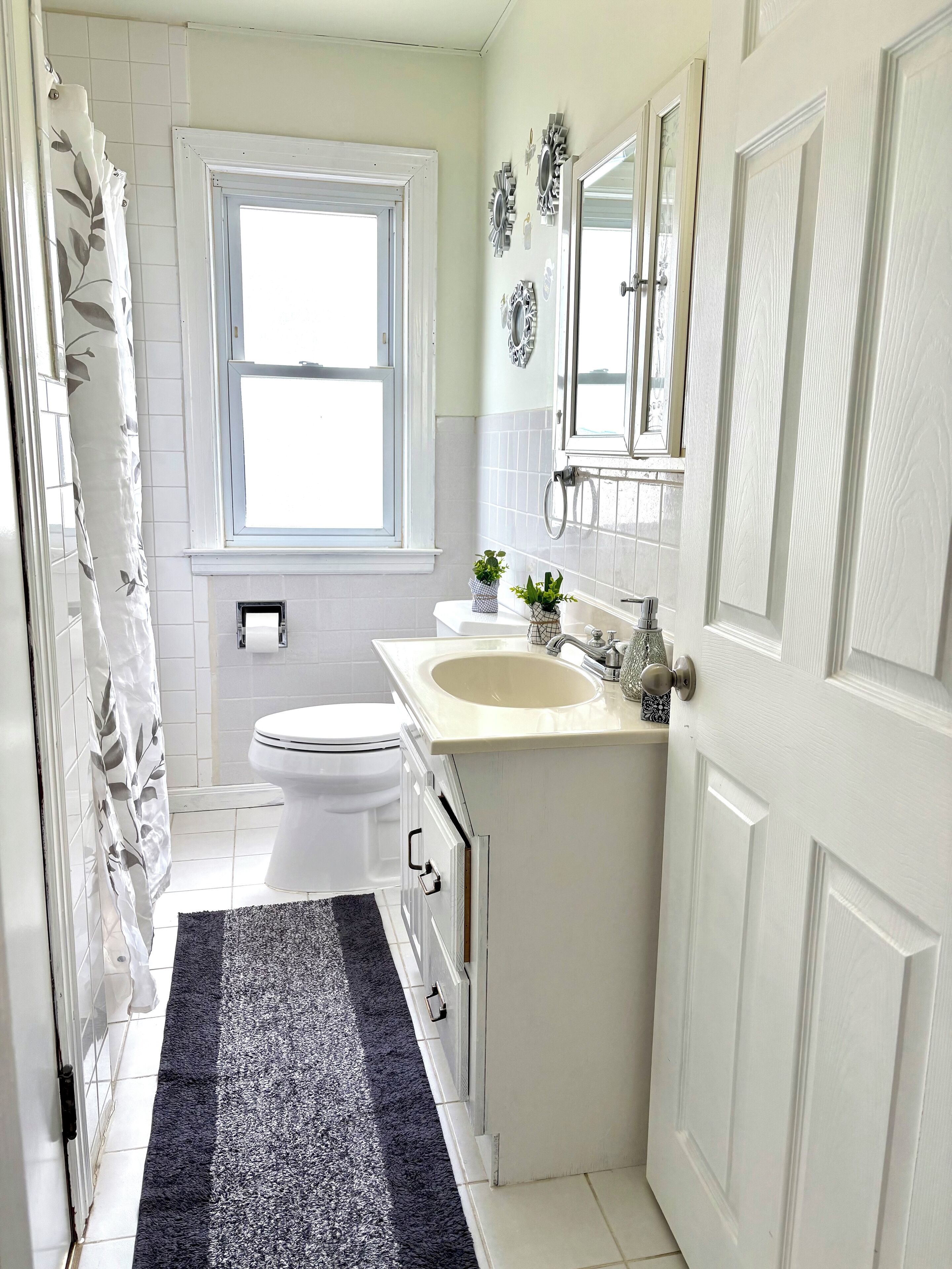 A compact bathroom with a toilet, sink, and window.