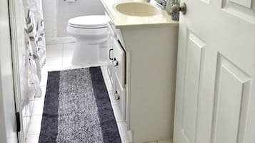 A compact bathroom with a toilet, sink, and window.