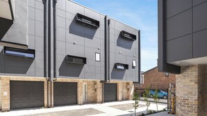 A modern building with a flat roof, large windows, and a brick base. - Stafford St Apartments by Urban Rest (Adelaide)