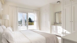 A spacious bedroom with a large bed, a dresser, and a mirror. - Villa Hope -Luxury 3-bedroom villa with AC, WiFi in lovely Buenas Noches (Buenas Noches)