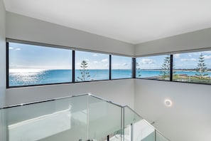A modern interior with large windows offering a coastal view. - Coastal Bliss with Marina Views-Neaby Cafes (Mandurah)