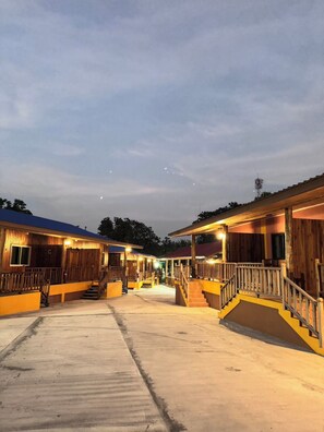 A hotel with multiple wooden buildings, a central open area, and a staircase leading to the upper levels. - Simple & Comfortable resort for seniors and family travelers (ตำบล แม่แรม)