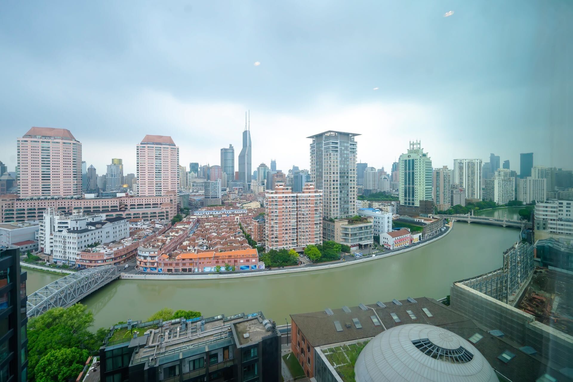 Un paisaje urbano con río, edificios altos y un puente.