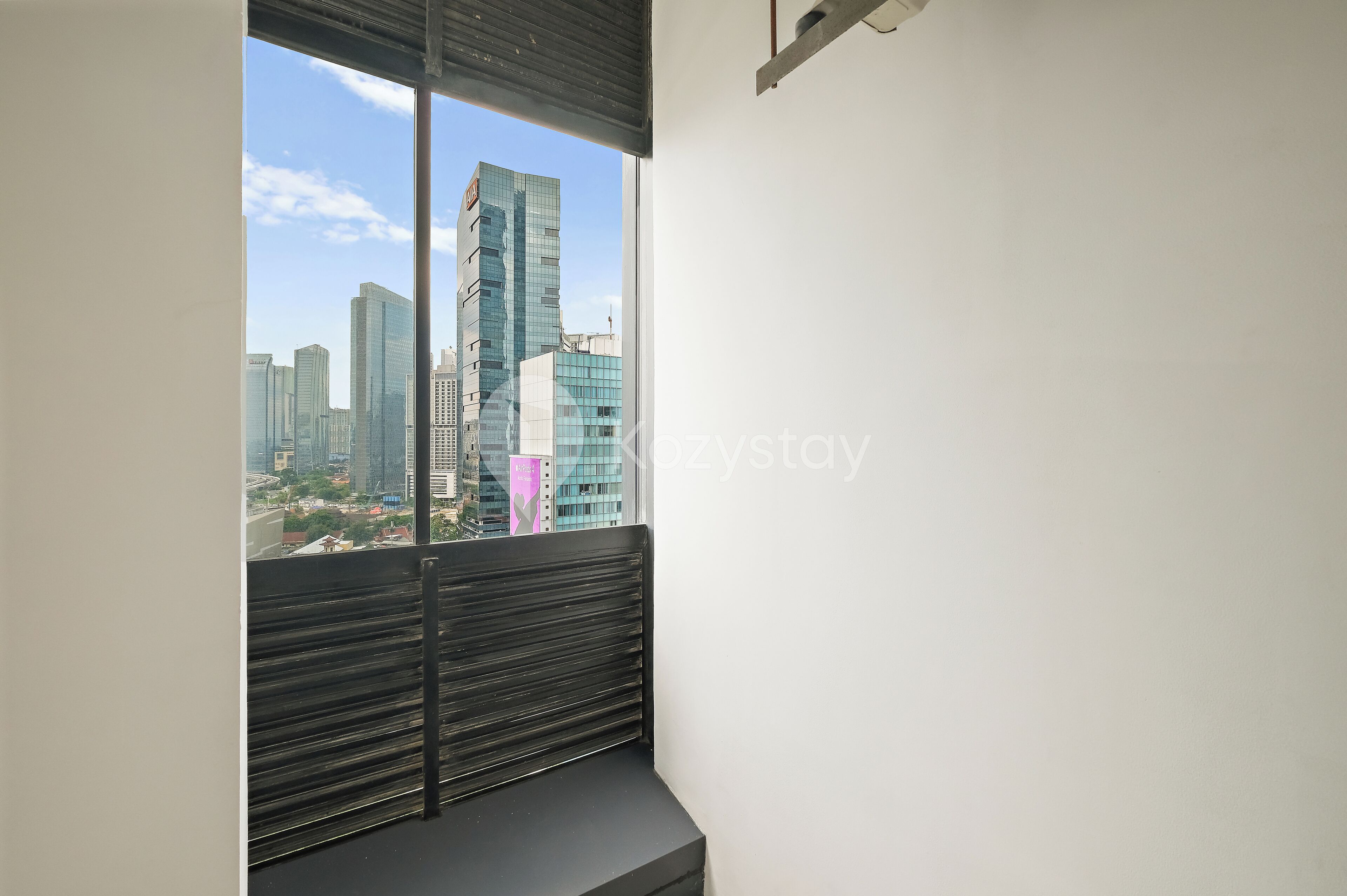 A room with a large window overlooking a cityscape with modern buildings.