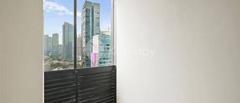 A room with a large window overlooking a cityscape with modern buildings.