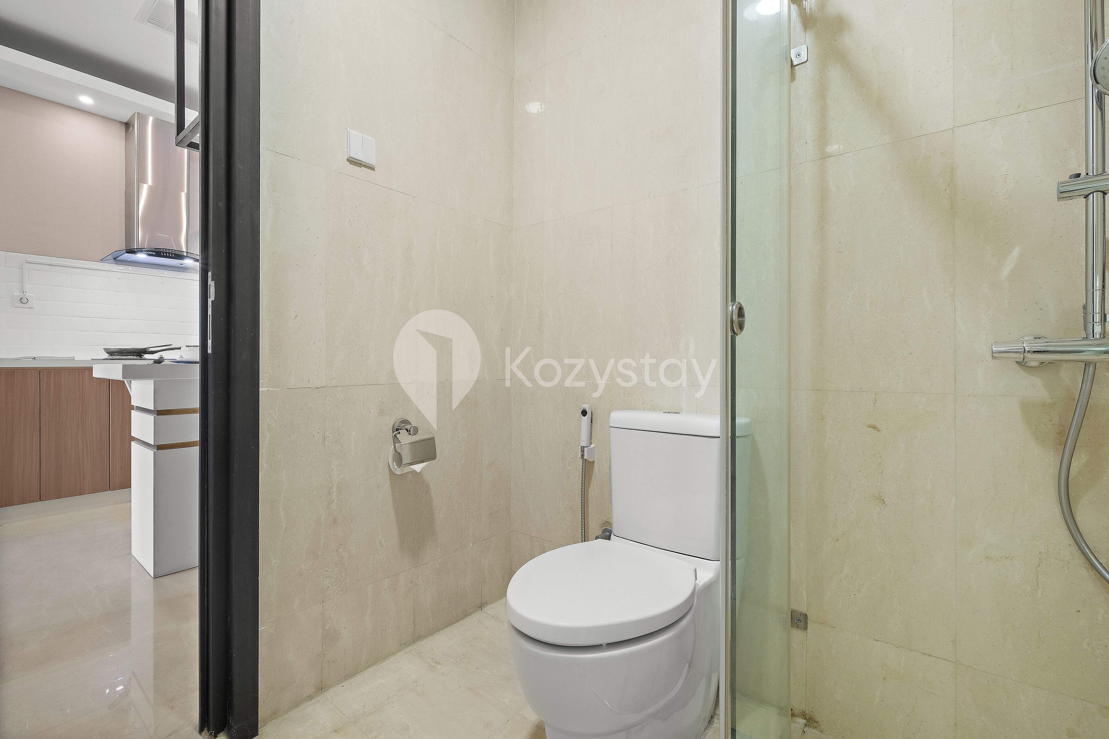 Un baño moderno con inodoro, ducha y zona de ducha con mampara de vidrio.