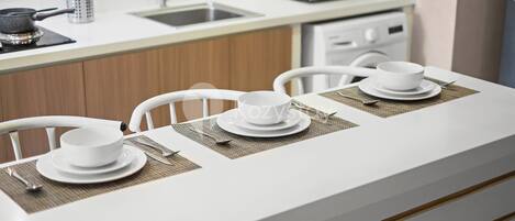 A modern kitchen with white countertops, a microwave, and a sink.