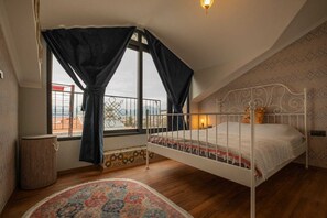 A bedroom with a bed, a window with curtains, a patterned rug, and a balcony with a railing. - Deniz Loft Fethiye (Fethiye)