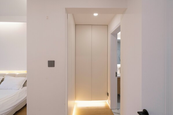 A narrow hallway with a bed on the left and a door at the end. - Zhome Riverside Garden-Near the Bund (Shanghai)