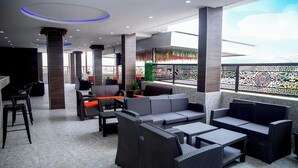 A modern outdoor seating area with wicker furniture and a view of the sky. - Skyline View Hotel and Suites (Abuja)