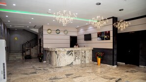 A lobby with a marble reception desk, a staircase, and a modern chandelier. - Skyline View Hotel and Suites (Abuja)