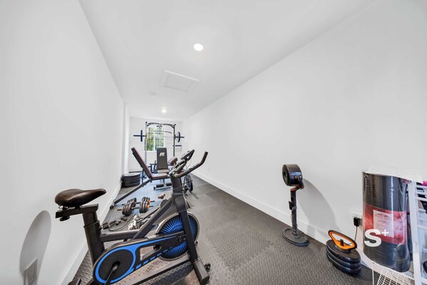 A gym with exercise bikes, a treadmill, and weight equipment.