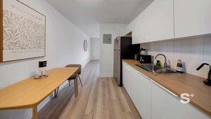 Eine moderne Küche mit weißen Schränken, einer Holz Arbeitsplatte und einem Edelstahlspülbecken.
