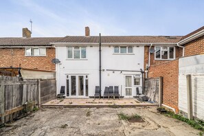 A two-story house with a white facade, a tiled roof, and a fenced backyard. - 3-bed - Sleeps 5 - Pets - Parking (Northolt)