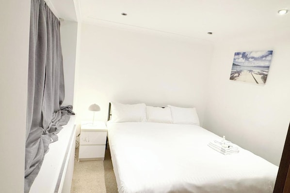 A small, neatly arranged bedroom with a single bed, a bedside table, a lamp, and a picture on the wall. - 3-bed - Sleeps 5 - Pets - Parking (Northolt)