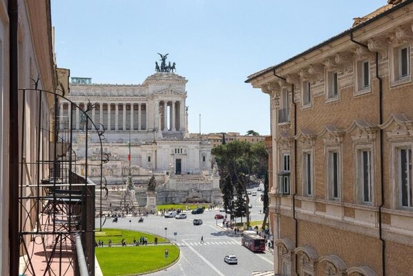 A view of a historic building with classical architecture, a central open plaza, and a busy street with vehicles and pedestrians. - Domus Sabina - Central Rome (Roma)