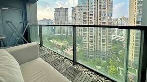 A modern apartment with a balcony, a sofa, and a view of high-rise buildings. - ZHome-Suhe Luxury Mansion-Near the Bund (Shanghai)